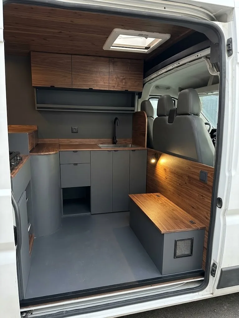 Rendu 3D d'un aménagement de fourgon Ducato avec cuisine walnut, banquette-lit et hayon arrière ouvert
